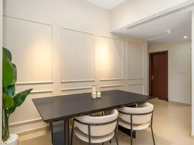 a dining room with a black table and white chairs at Comfy 2BR Amwaj 4 Sleeps 10 in Dubai