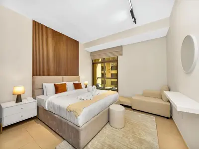 a bedroom with a large bed and a couch at Comfy 2BR Amwaj 4 Sleeps 10 in Dubai