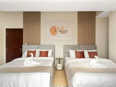 two beds with swans on them in a bedroom at Comfy 2BR Amwaj 4 Sleeps 10 in Dubai