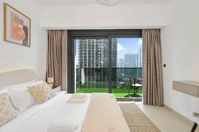 a bedroom with a bed and a large window at Modern 1BR in ACT Tower 1 in Dubai