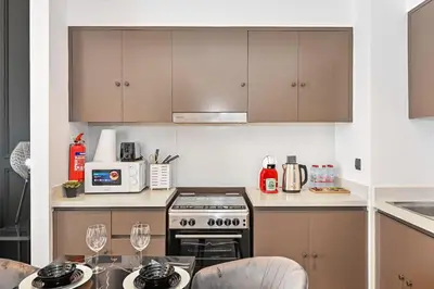 a kitchen with brown cabinets and a stove top oven at 2BR Pool Burj View Dubai Mall in Dubai