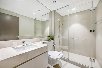 a bathroom with a shower and a toilet and a sink at 2BR Pool Burj View Dubai Mall in Dubai