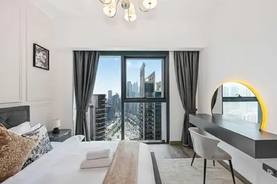 a bedroom with a bed and a large window at 2BR Pool Burj View Dubai Mall in Dubai