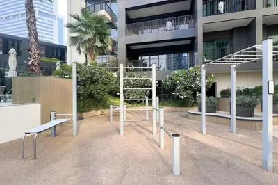 a playground in front of a tall building at Waterfront 1 BR - Canal View - Fully Furnished - Business Bay - 15 Mins to Dubai Mall and Burj Khalifa in Dubai