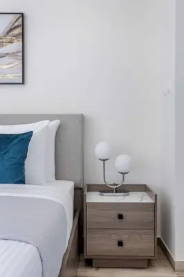 a bedroom with a bed and a nightstand with two lamps at Waterfront 1 BR - Canal View - Fully Furnished - Business Bay - 15 Mins to Dubai Mall and Burj Khalifa in Dubai