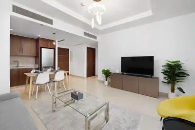 a living room with a tv and a table with chairs at Stunning 1 Bedroom at Boulevard Point with Infinity Pool connected to Dubai Mall by Luxury Space in Dubai