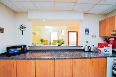 a kitchen with a counter top with a tv on it at Best Deal I Spacious Apartment I Full Amenities including Balcony, Pool, Gym, Kids Play Area in Dubai