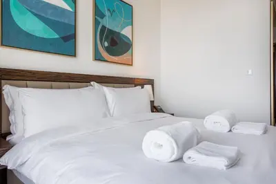 a white bed with towels on top of it at Maison Privee - Chic Coastal Escape with Open Sea Vws on Palm Entry in Dubai