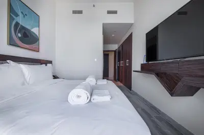 a bedroom with a large white bed with towels on it at Maison Privee - Chic Coastal Escape with Open Sea Vws on Palm Entry in Dubai