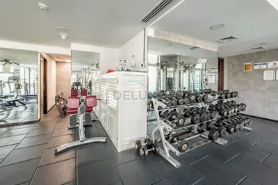 a gym with dumbbells and a mirror at Studio Steps from JBR Beach and Marina Walk, Conveniently located near Ain Dubai, Dec Towers T2, Dubai Marina by Deluxe Holiday Homes in Dubai