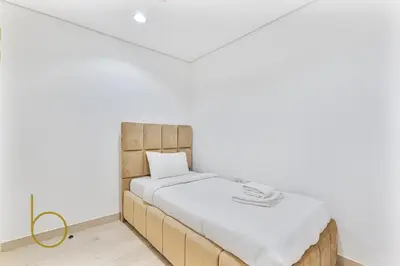 a bed in a room with a white wall at Bookable - 3 Bedroom in Mayas Geneva, JVC in Dubai