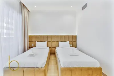 two beds in a room with white walls at Bookable - 3 Bedroom in Mayas Geneva, JVC in Dubai