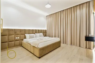 a bedroom with a large bed and a large window at Bookable - 3 Bedroom in Mayas Geneva, JVC in Dubai