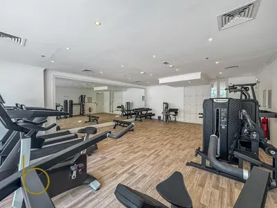 a gym with treadmills and exercise bikes in it at Bookable - 3 Bedroom in Mayas Geneva, JVC in Dubai