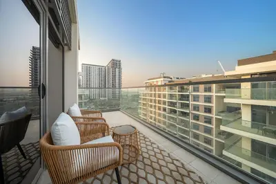 a balcony with chairs and a view of a building at FIRST CLASS 2BR Timeless Vibes & Pool View in Dubai