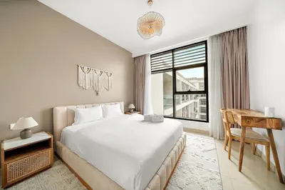 a bedroom with a bed and a desk and a window at FIRST CLASS 2BR Timeless Vibes & Pool View in Dubai