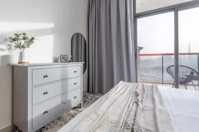 a bedroom with a bed and a dresser and a window at Full Dubai Skyline View on High Floor in Dubai
