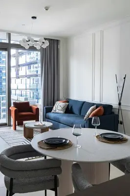 a living room with a blue couch and a table at Design 1br Apartment with Dubai Marina View in Marina Gate 2 in Dubai