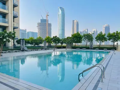 a large swimming pool with a city in the background at Luxury 2BR Downtown Burj View, Heart of Downtown in Dubai