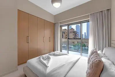 a bedroom with a bed and a large window at Luxury 2BR Downtown Burj View, Heart of Downtown in Dubai