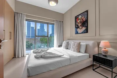 a white bedroom with a large bed and a window at Luxury 2BR Downtown Burj View, Heart of Downtown in Dubai