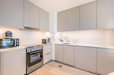 a kitchen with white cabinets and a stove at Creek Views 1BR, Short Drive to Ras Al Khor Sanctuary and Festival City Mall, Rosewater at Creek Beach Building 3, Dubai Creek Harbour by Deluxe Holiday Homes in Dubai