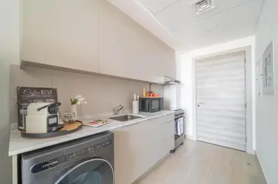 a kitchen with a washer and dryer on a counter at Frank Porter - Bloom Tower C in Dubai