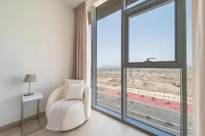 a white chair in a room with a large window at Frank Porter - Bloom Tower C in Dubai