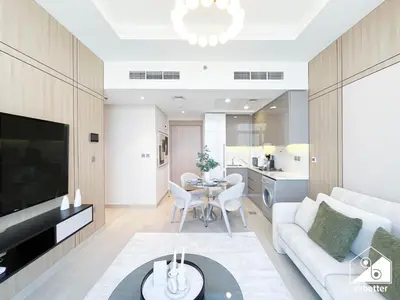 a living room with a white couch and a table at Elegant 1BR at Azizi Riviera l Prime Location in Dubai