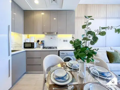 a kitchen and a dining room with a table and chairs at Elegant 1BR at Azizi Riviera l Prime Location in Dubai