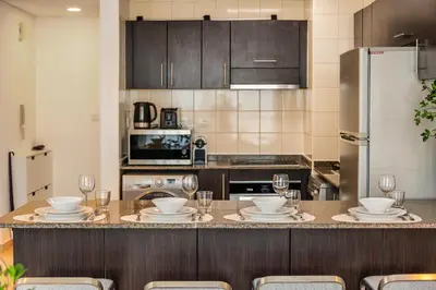 a kitchen with a table with plates and wine glasses at 1BD Canal View for 4 in Bay Central, Dubai Marina in Dubai