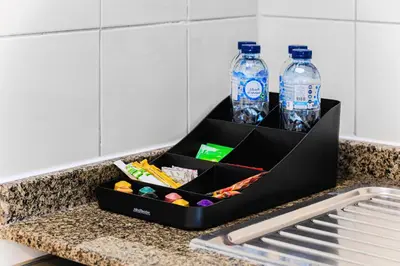 a black box on a counter with two bottles of water at 1BD Canal View for 4 in Bay Central, Dubai Marina in Dubai