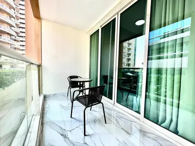a balcony with two chairs and a table on it at Stylish 1 Plus Maid's 5 mins to Metro at Marina Park in Dubai
