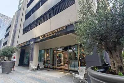 a store front of a building with chairs and a tree at Stylish 1BR DunyaTower Apartment 2min to DubaiMall in Dubai