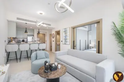 a living room with a couch and a kitchen at Vogue Damac Hills Golf Gate near First Avenue Mall, Two Bedroom Apartment with Balcony and Vibrant Community View, Access to all Amenities in Dubai