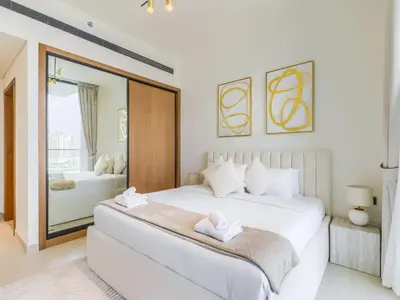 a white bedroom with a large bed and a window at TRPS - Binghatti Lavender, JVC - Premium 1BR Retreat, Fully Furnished in Dubai