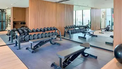 a gym with rows of exercise bikes and benches at TRPS - Binghatti Lavender, JVC - Premium 1BR Retreat, Fully Furnished in Dubai