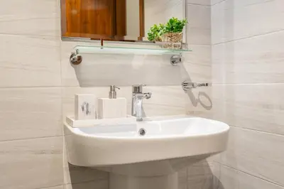 a bathroom with a white sink and a mirror at Luxury Apartment l 2 min walk from Dubai Mall in Dubai