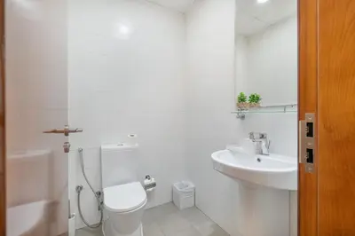 a white bathroom with a toilet and a sink at Luxury Apartment l 2 min walk from Dubai Mall in Dubai