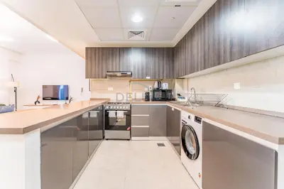 a large kitchen with stainless steel appliances and counters at Few Metres Walk to Metro, Minutes Drive from Ibn Battuta Mall, Victoria Residency, Al Furjan by Deluxe Holiday Homes in Dubai