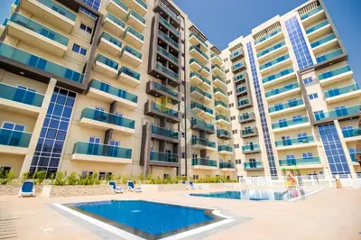an image of an apartment building with a swimming pool at Few Metres Walk to Metro, Minutes Drive from Ibn Battuta Mall, Victoria Residency, Al Furjan by Deluxe Holiday Homes in Dubai