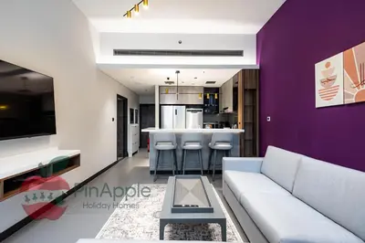 a living room with a white couch and a purple wall at Beautiful Brand New Spacious 1BR in Dubai