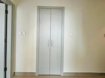 a white closet with two doors in a room at Homelike Charm High-End Furnished and Luxurious in Dubai