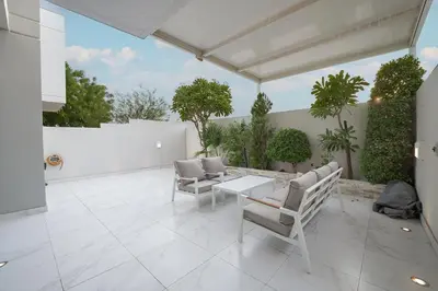 a patio with chairs and a table on a patio at EasyGo-Elavated Urban Living Stylish 3Bedroom townhouse in Dubai