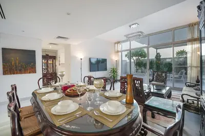 a dining room with a table and chairs at EasyGo-Elavated Urban Living Stylish 3Bedroom townhouse in Dubai