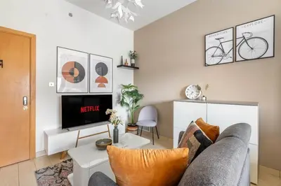 a living room with a couch and a tv at Luxury Studio Apartment in Dubai