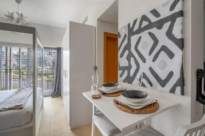 a white room with a bed and a mirror at Luxury Studio Apartment in Dubai