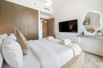 a bedroom with a large white bed and a tv at Appealing 2BR at 17 Icon Bay, Dubai Creek Harbour in Dubai