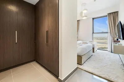 a bedroom with two beds and a tv and a window at Appealing 2BR at 17 Icon Bay, Dubai Creek Harbour in Dubai