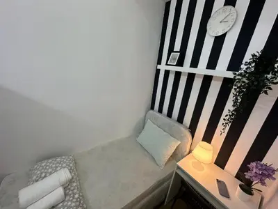 a small room with a bench with a clock on the wall at Simple Stay Partition Room In Barsha heights Tecom in Dubai